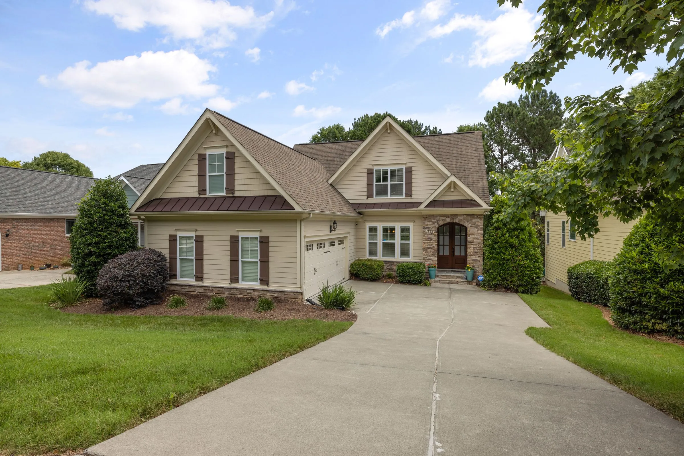 Craftsman-style home with a dark shingle roof and stone entry